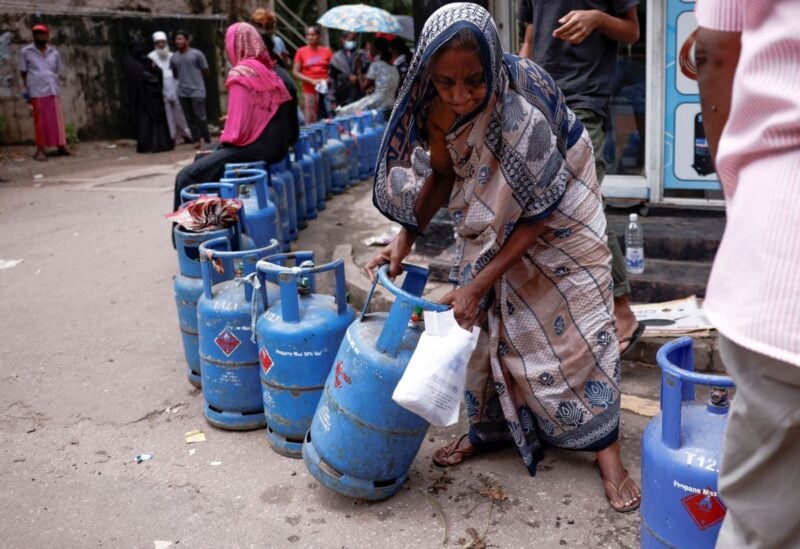 A woman moves a gas tank as she stands in line to buy another tank near a distributor, amid the country's economic crisis, in Colombo, Sri Lanka, June 1, 2022. REUTERS/Dinuka Liyanawatte