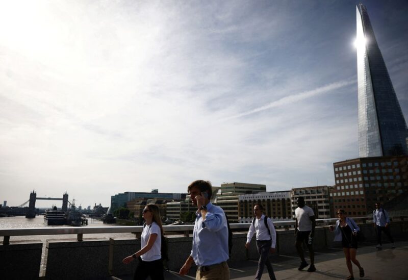 Commuters walk over London Bridge during warm weather in London, Britain