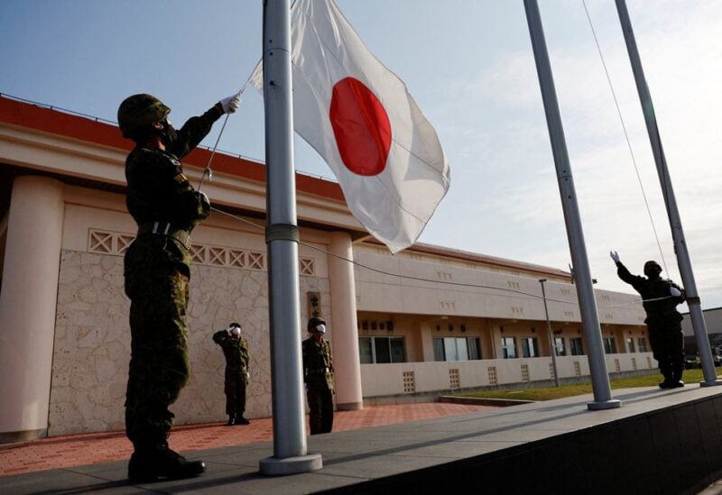 Members of the Japan Ground Self-Defense Force (JGSDF) bring down the Japanese national flag in the early evening, at JGSDF Miyako camp on Miyako Island, Okinawa prefecture, Japan April 20, 2022. Picture taken April 20, 2022. REUTERS/Issei Kato/File Photo