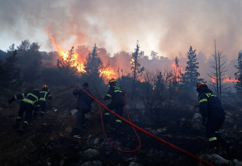 Firefighters and volunteers try to extinguish a wildfire near Vari, south of Athens, Greece June 4, 2022. REUTERS/Costas Baltas