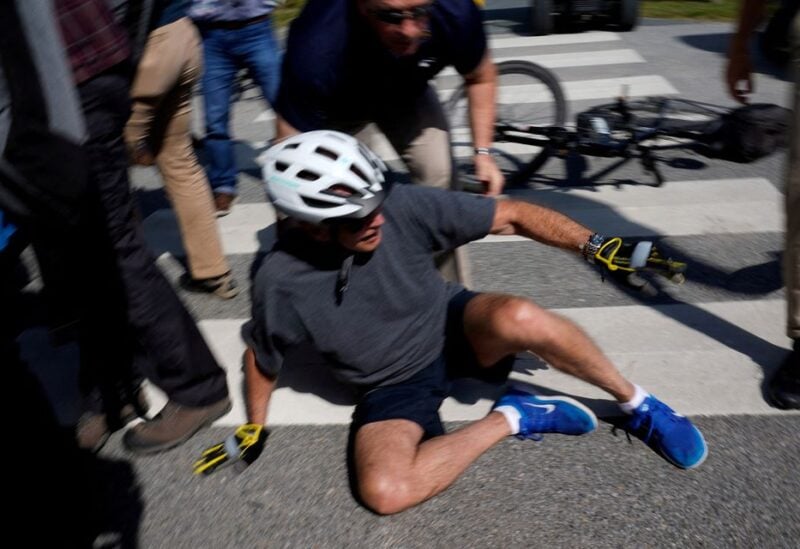 U.S. President Joe Biden falls to the ground after riding up to members of the public during a bike ride in Rehoboth Beach, Delaware, U.S., June 18, 2022. REUTERS/Elizabeth Frantz