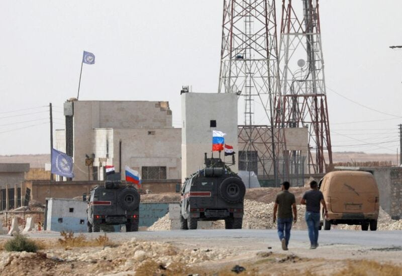 Russian and Syrian national flags flutter on military vehicles near Manbij, Syria