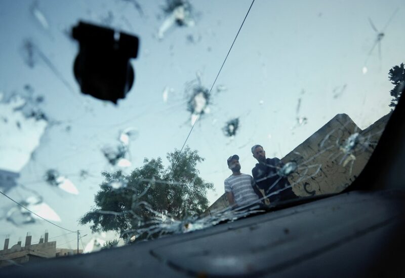 People look at a damaged vehicle following an Israeli raid in Jenin, in the Israeli-occupied West Bank June 17, 2022. REUTERS/Mohamad Torokman