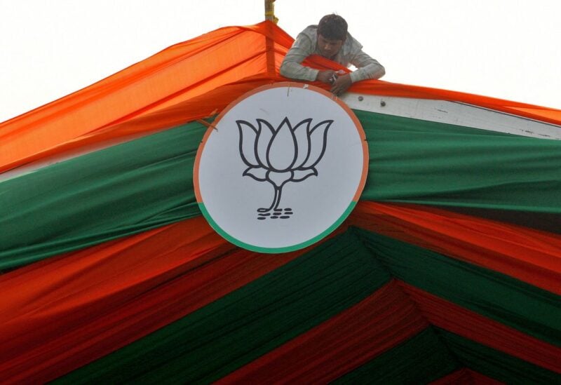 A man installs the symbol of India's ruling Bharatiya Janata Party (BJP) on a tent during an election campaign rally by the party in Prayagraj, India, February 24, 2022. REUTERS/Ritesh Shukla