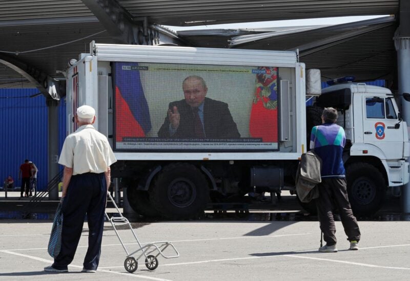 Russian President Vladimir Putin is seen on a screen broadcasting Russian TV news programs at a humanitarian aid distribution point during Ukraine-Russia conflict in the southern port city of Mariupol, Ukraine May 30, 2022. REUTERS/Alexander Ermochenko