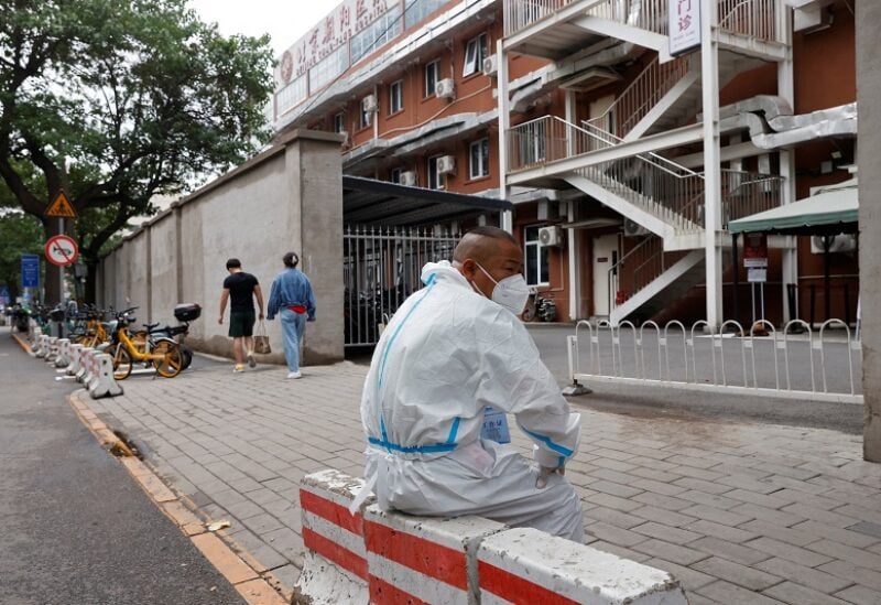 A worker in a protective suit sits outside a fever clinic of a hospital, following the coronavirus disease (COVID-19) outbreak in Beijing, China June 13, 2022. REUTERS/Carlos Garcia Rawlins