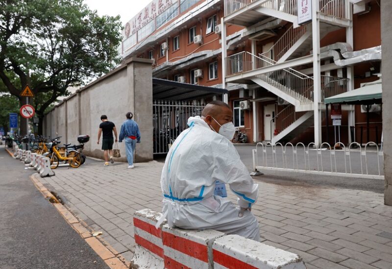 A worker in a protective suit sits outside a fever clinic of a hospital, following the coronavirus disease (COVID-19) outbreak in Beijing, China June 13, 2022. REUTERS/Carlos Garcia Rawlins