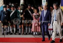 U.S. President Joe Biden walks with Bavaria's State Premier Markus Soeder past people in traditional Bavarian clothes as Biden arrives for a G7 summit aboard Air Force One at Munich International Airport near Munich, Germany June 25, 2022. REUTERS/Jonathan Ernst