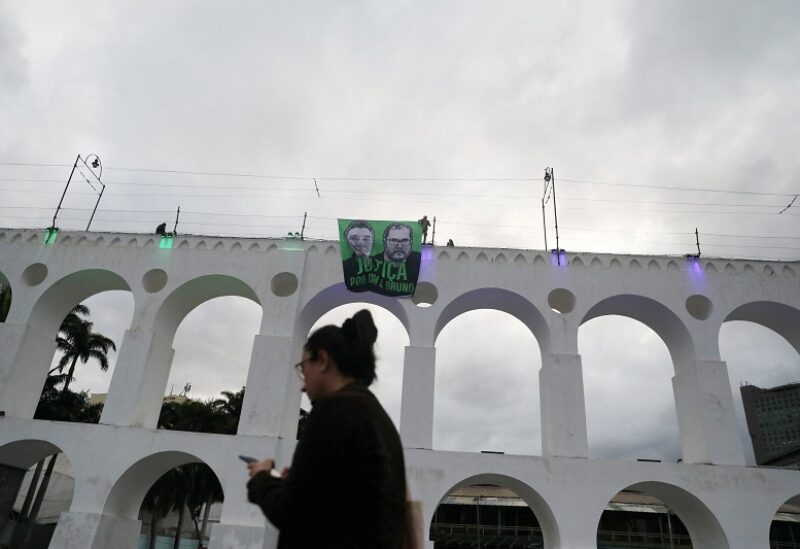 A banner with the images of British journalist Dom Phillips and Brazilian Indigenous affairs specialist Bruno Pereira, both killed in the Amazon, is seen on the Arcos da Lapa (Lapa Arches) during a demonstration in Rio de Janeiro Brazil 26, 2022. REUTERS/Pilar Olivares