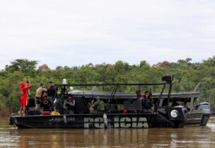 Police officers and rescue team members stand on a boat during the search operation for British journalist Dom Phillips and indigenous expert Bruno Pereira, who went missing while reporting in a remote and lawless part of the Amazon rainforest, near the border with Peru, in Atalaia do Norte, Amazonas state, Brazil, June 12, 2022.REUTERS/Bruno Kelly