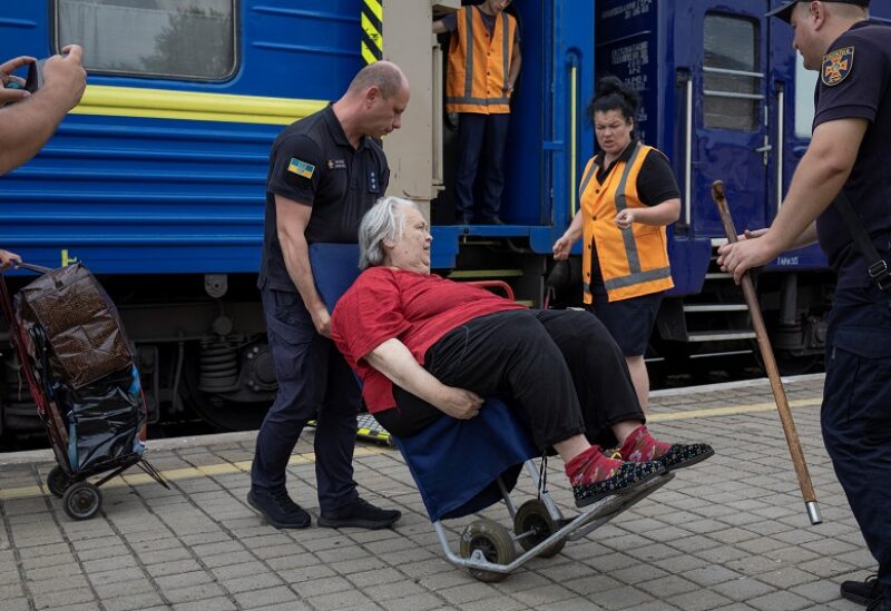 Ukrainian police officers help Elena from Lysychansk to board a train to Dnipro and Lviv during an evacuation of civilians from war-affected areas of eastern Ukraine, amid Russia's invasion of the country, in Pokrovsk, Donetsk region, Ukraine, June 25, 2022. REUTERS/Marko Djurica