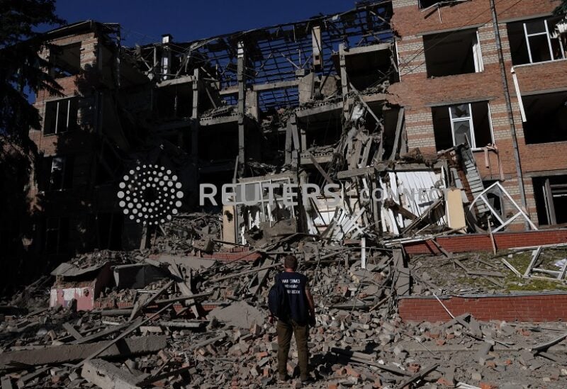 A worker from the war crimes prosecutor's office takes in the damage from overnight shelling that landed on a building of Kharkiv's Housing and Communal College as Russia's attack on Ukraine continues in Kharkiv, Ukraine, June 21, 2022. REUTERS/Leah Millis