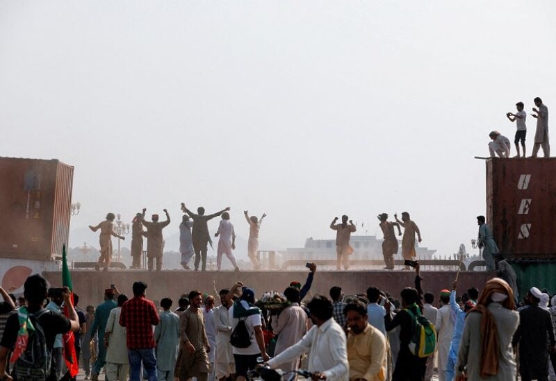 Supporters of the Pakistan Tehreek-e-Insaf (PTI) political party react after they remove a shipping container, used to block the road leading to Red Zone, during a protest march called by ousted Prime Minister Imran Khan in Islamabad, Pakistan May 26, 2022. REUTERS/Akhtar Soomro TPX IMAGES OF THE DAY
