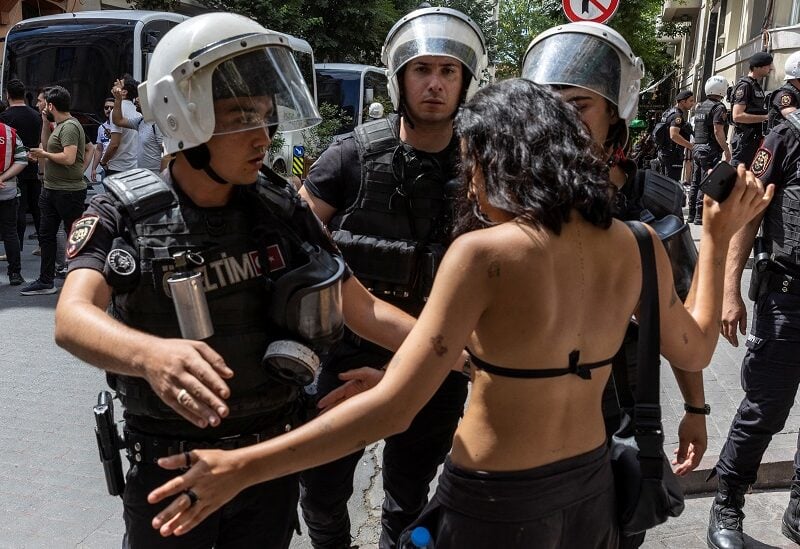 Police officers prevent an activist from marching in a pride parade, which was banned by local authorities, in central Istanbul, Turkey June 26, 2022. REUTERS/Umit Bektas