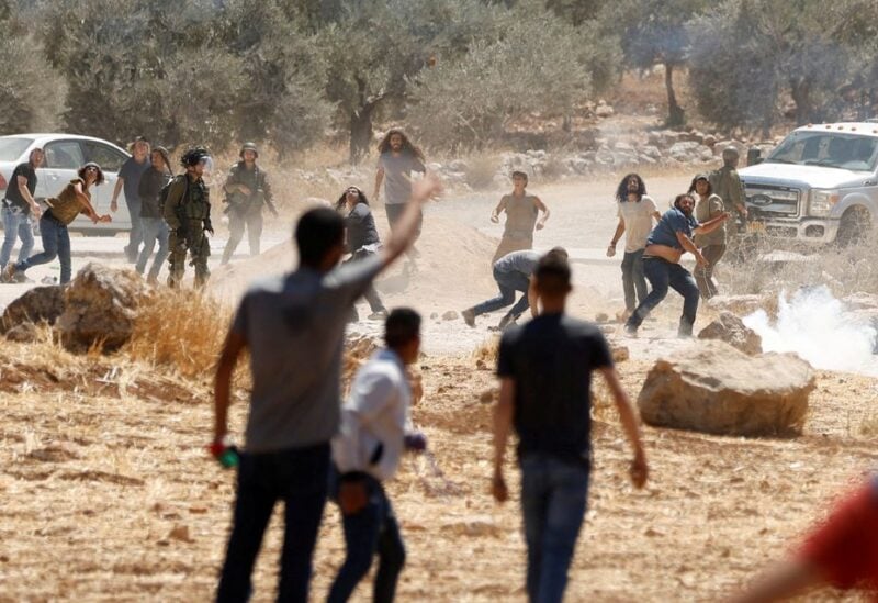 Palestinian protesters clash with Israeli settlers during a protest against Israeli settlement activity in Al Mughayyir village, in the Israeli-occupied West Bank July 29, 2022. REUTERS/Mohamad Torokman