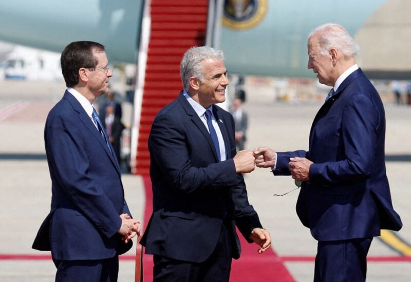 Israeli President Isaac Herzog looks on as Prime Minister Yair Lapid bumps fists with U.S. President Joe Biden during a welcoming ceremony at Ben Gurion International Airport in Lod, near Tel Aviv, Israel, July 13, 2022. REUTERS/Amir Cohen