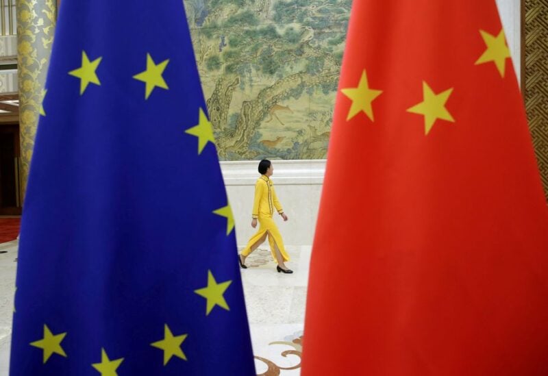 An attendant walks past EU and China flags ahead of the EU-China High-level Economic Dialogue at Diaoyutai State Guesthouse in Beijing, China June 25, 2018. REUTERS/Jason Lee/