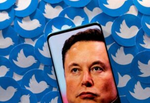 An image of Elon Musk is seen on smartphone placed on printed Twitter logos in this picture illustration taken April 28, 2022. REUTERS/Dado Ruvic/Illustration