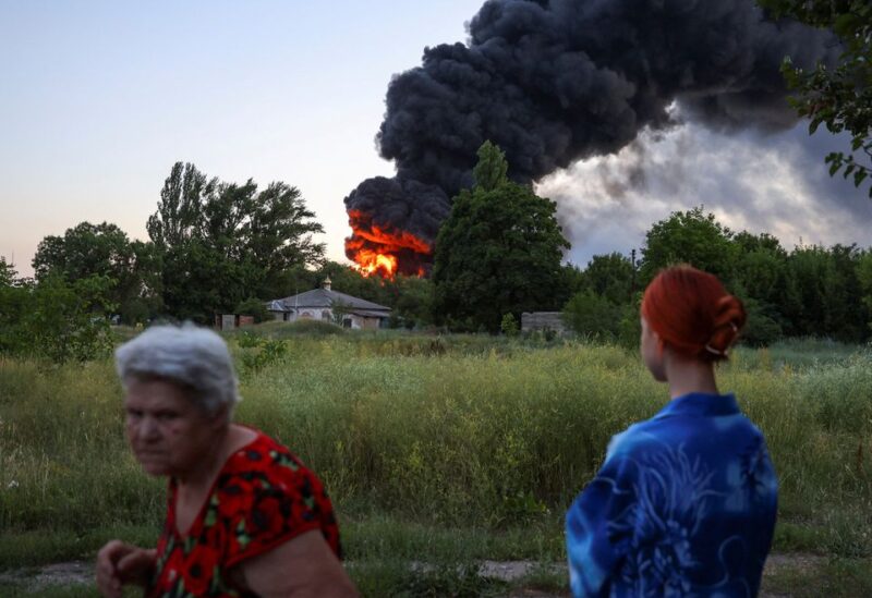 Local residents look on as smoke rises after shelling during Ukraine-Russia conflict in Donetsk, Ukraine July 7, 2022