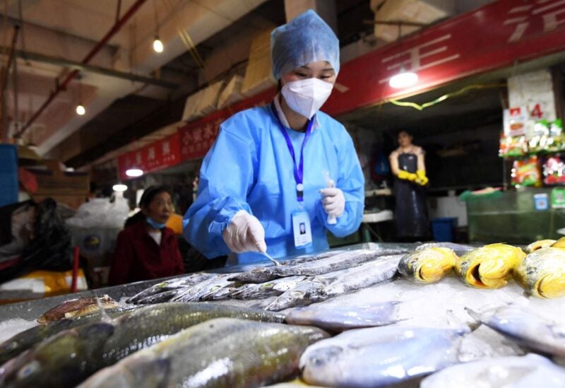 A staff member of Nanming district's Center for Disease Control and Prevention collects a swab from frozen fish for nucleic acid testing following the coronavirus disease (COVID-19) outbreak, at Wandong market in Guiyang, Guizhou province, China July 1, 2020. Picture taken July 1, 2020. cnsphoto via REUTERS