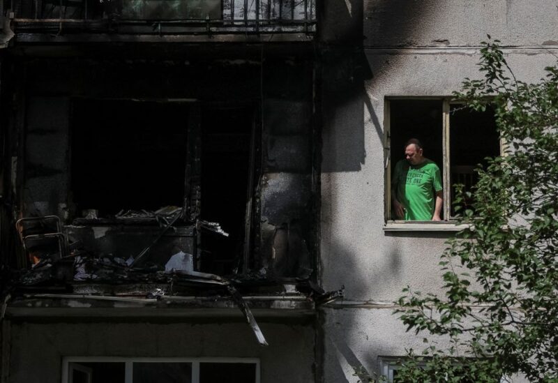 A local resident looks out through a broken window in his flat in a residential building damaged by a Russian military strike, amid Russia's invasion on Ukraine, in Kramatorsk, in Donetsk region, Ukraine July 19, 2022. REUTERS/Gleb Garanich