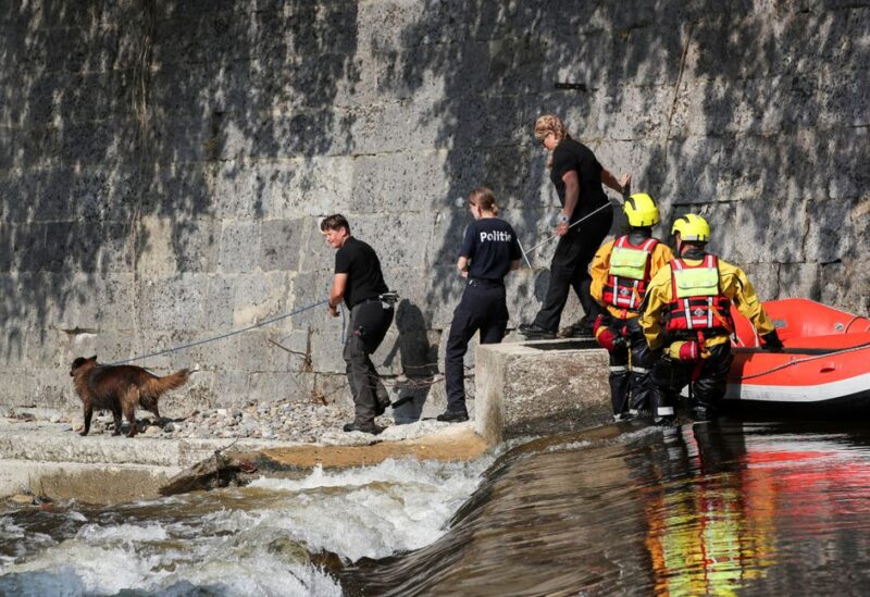 Rescue workers, along with Dutch and Belgian police officers with a dog, search for victims after heavy rainfall in Verviers, Belgium, July 23, 2021