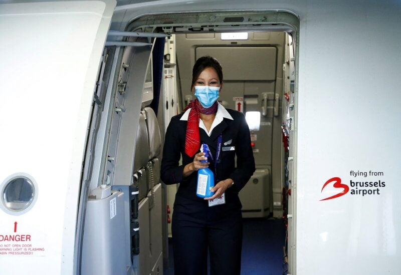 A flight attendant wearing a protective mask holds disinfectant spray onboard a Brussels Airlines aircraft before the take-off at the Zaventem International Airport, as Belgium eases restrictions aimed to contain the spread of the coronavirus disease (COVID-19) outbreak, near Brussels, Belgium June 15, 2020. REUTERS/Francois Lenoir/File Photo