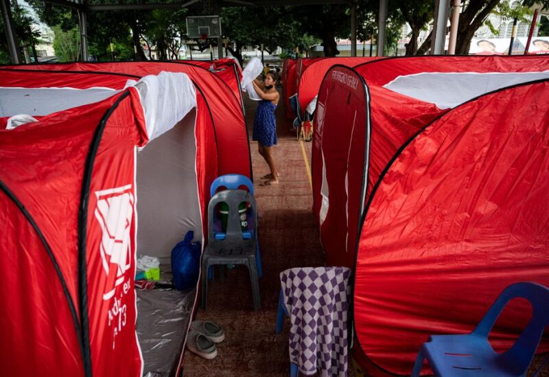 A woman prepares her modular tent after evacuating from her home in the aftermath of an earthquake in Bangued, Abra province, Philippines, July 28, 2022. REUTERS/Lisa Marie David