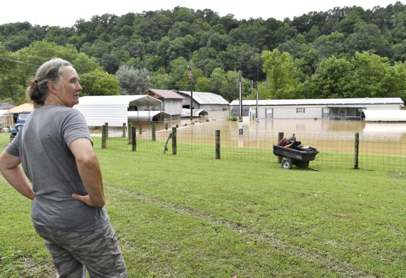 Bonnie Combs stands by and watches her property become covered by the North Fork of the Kentucky River in Jackson, Ky., Thursday, July 28, 2022. Flash flooding and mudslides were reported across the mountainous region of eastern Kentucky, where thunderstorms have dumped several inches of rain over the past few days. (AP Photo/Timothy D. Easley)