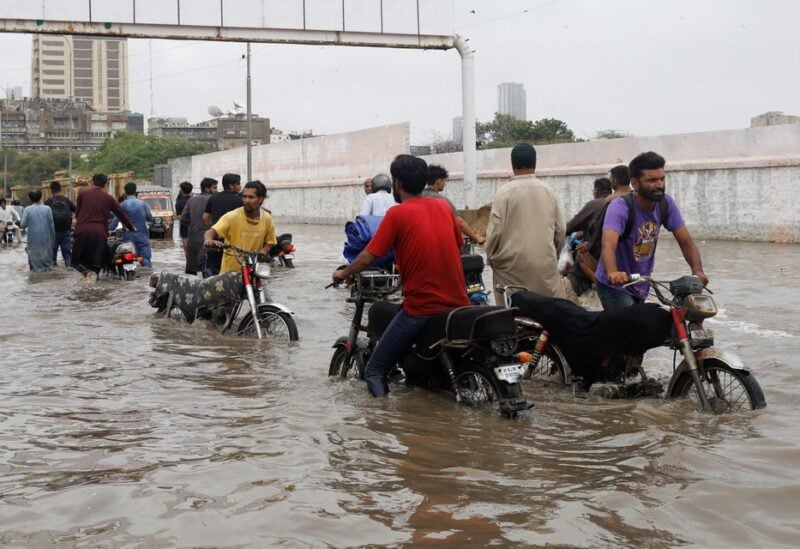 Residents commute through a flooded road during the monsoon season in Karachi, Pakistan July 9, 2022. REUTERS/Akhtar Soomro