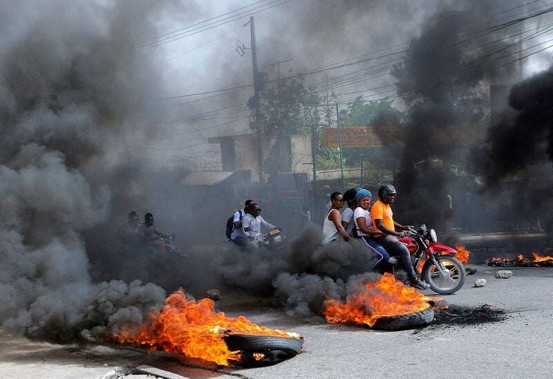 Motorcycle drivers pass through a burning road block as anger mounted over fuel shortages that have intensified as a result of gang violence, in Port-au-Prince, Haiti, July 13, 2022. REUTERS/Ralph Tedy Erol REFILE - QUALITY REPEAT