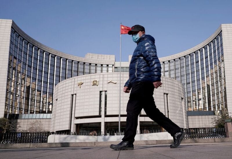 A man wearing a mask walks past the headquarters of the People's Bank of China, the central bank, in Beijing, China, February 3, 2020. REUTERS/Jason Lee