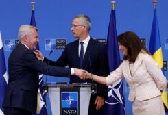 Sweden's Foreign Minister Ann Linde and Finland's Foreign Minister Pekka Haavisto shake hands during a news conference with NATO Secretary General Jens Stoltenberg