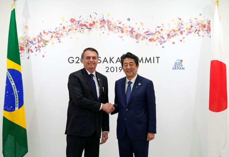 Brazilian President Jair Bolsonaro (L) shakes hands with Japanese Prime Minister Shinzo Abe prior to their bilateral meeting during the second day of the G20 summit in Osaka, Japan