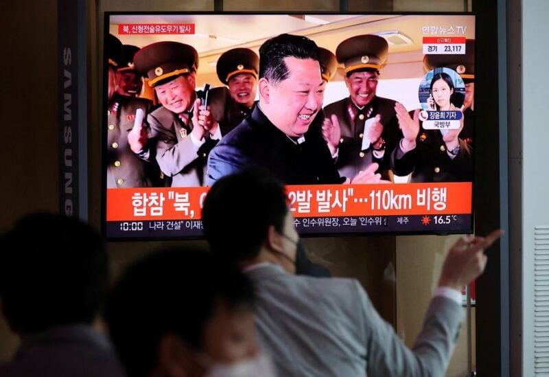 People watch a television broadcasting a news report on North Korea's new type of tactical
