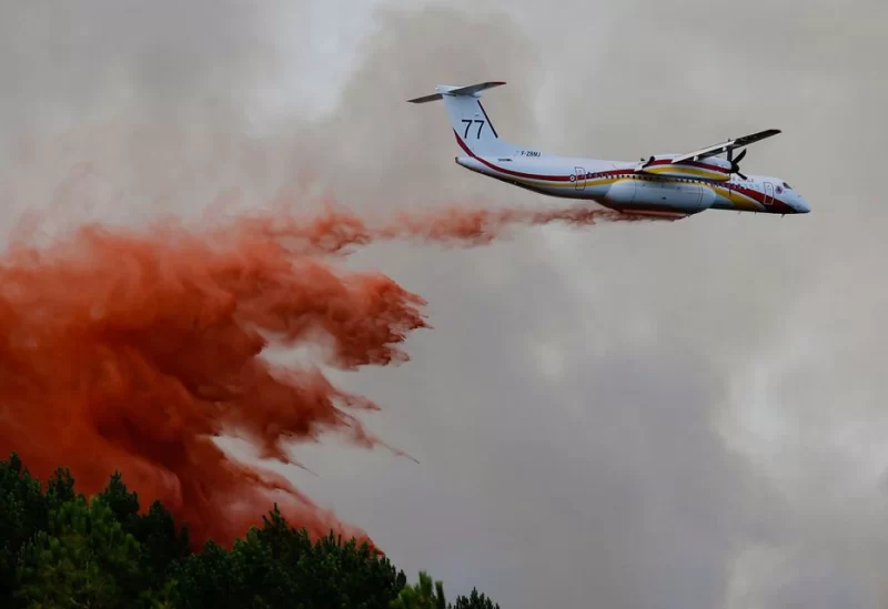 A firefighting plane drops flame retardant to extinguish a fire in Guillos, as wildfires continue to spread in the Gironde region of southwestern France