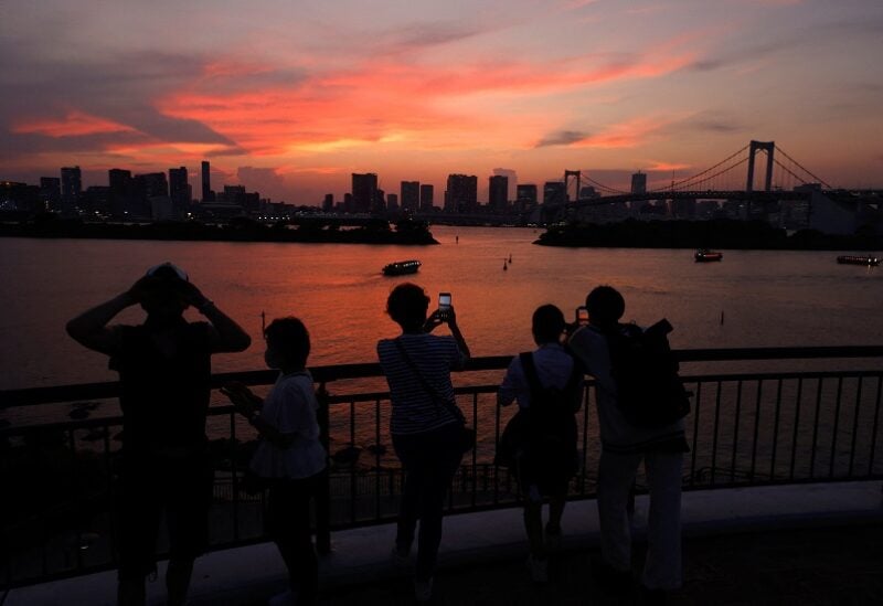 People cool off on an observation bridge at dusk as the region around Tokyo marked its seventh straight day of temperatures above 35 Celsius (95 Fahrenheit) and faces a hot weekend, at Odaiba Marine Park in Tokyo, Japan, July 1, 2022. REUTERS/Issei Kato
