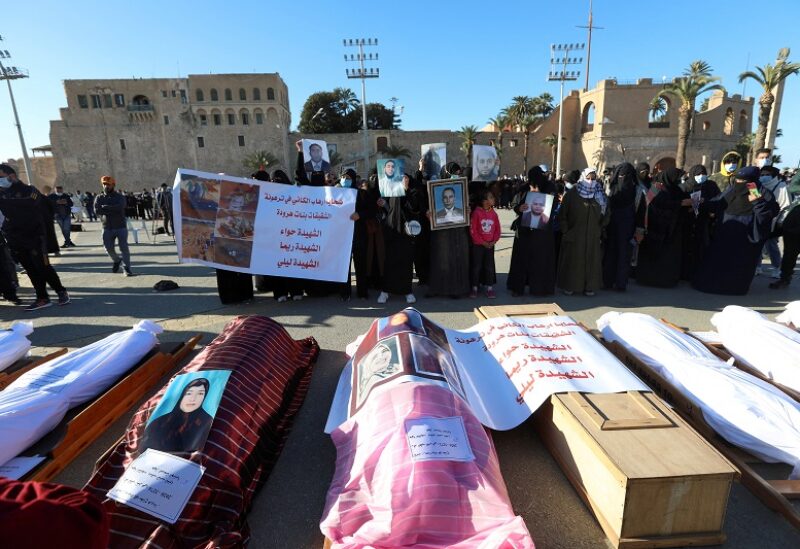 FILE PHOTO: Mourners show portraits near bodies which were exhumed from a mass grave in Tarhouna, before getting reburied in Tripoli, Libya January 22, 2021. REUTERS/Hazem Ahmed/File Photo