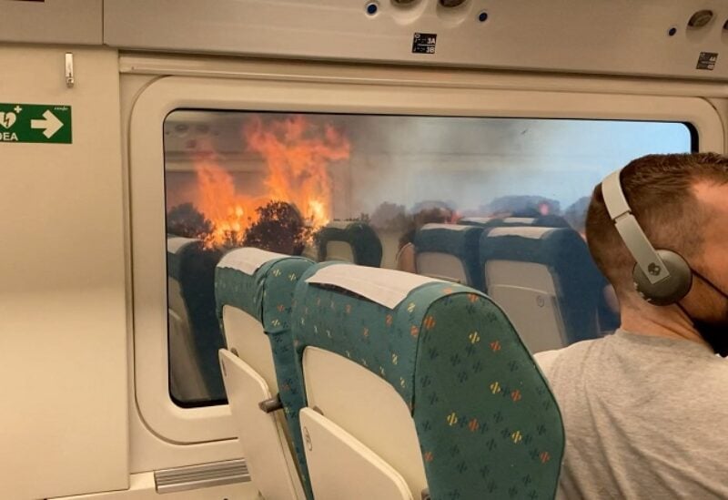 Passengers look at the wildfire from train, near Zamora, Spain, July 18, 2022, in this screen grab obtained from a social media video. Francisco Seoane Perez/via REUTERS THIS IMAGE HAS BEEN SUPPLIED BY A THIRD PARTY. MANDATORY CREDIT. NO RESALES. NO ARCHIVES.