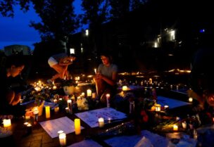 Community members light candles at a memorial site near the parade route the day after a mass shooting at a Fourth of July parade in the Chicago suburb of Highland Park, Illinois, U.S. July 5, 2022. REUTERS/Cheney Orr
