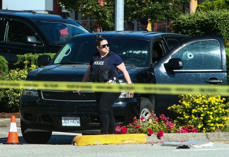 A police officer walks next to a car with bullet holes on the windows at a crime scene after authorities alerted residents of multiple shootings targeting transient victims in the Vancouver suburb of Langley, British Columbia, Canada July 25, 2022. REUTERS/Jesse Winter