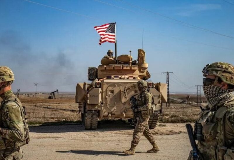 US soldiers walk while on patrol by the Suwaydiyah oil fields in Syria's northeastern Hasakah province on February 13, 2021.