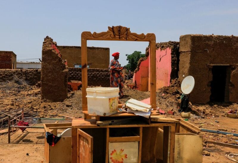 A woman collects her belongings after sustaining water damage to her house during floods in Al-Managil locality, in Jazeera State, Sudan August 23, 2022. REUTERS/Mohamed Nureldin Abdallah