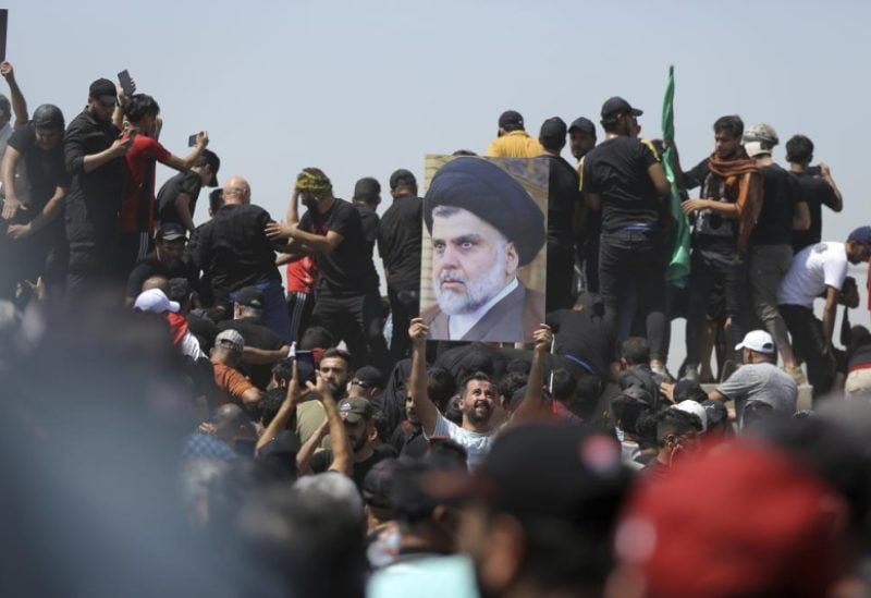A protester holds a poster depicting Shiite cleric Muqtada al-Sadr on a bridge leading towards the Green Zone area in Baghdad, Iraq, Saturday, July 30, 2022 — days after hundreds breached Baghdad's parliament Wednesday chanting anti-Iran curses in a demonstration against a nominee for prime minister by Iran-backed parties. Iraq’s political crisis shows no signs of abating weeks after followers of an influential cleric stormed parliament. That’s despite rising public anger over a debilitating gridlock that has further weakened the country’s caretaker government and its ability to provide basic services. (AP Photo/Anmar Khalil, File)