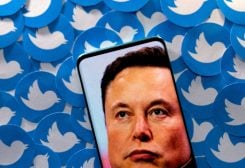 An image of Elon Musk is seen on smartphone placed on printed Twitter logos in this picture illustration taken April 28, 2022. REUTERS/Dado Ruvic/Illustration/File Photo