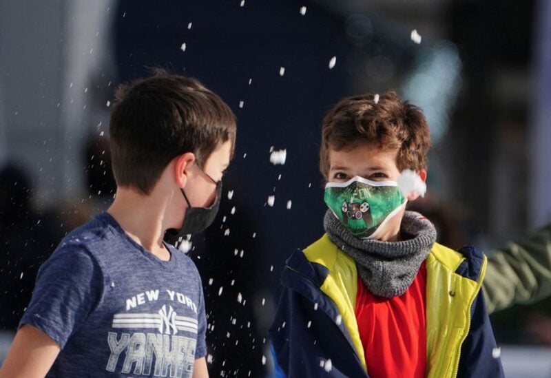 Children wearing protective masks toss snow at each other as they skate at Bryant Park during the coronavirus disease (COVID-19) pandemic in the Manhattan borough of New York City, New York, U.S., January 14, 2022. REUTERS/Carlo Allegri