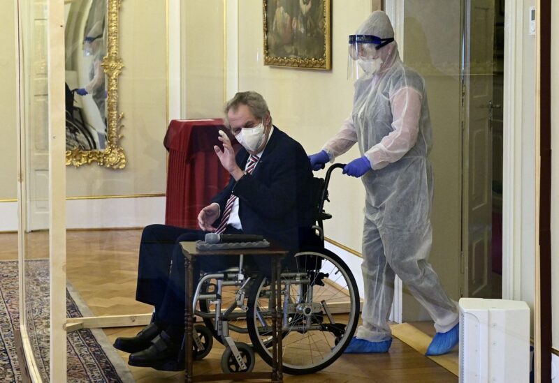 Czech President Milos Zeman, separated by a transparent wall after testing positive for the coronavirus disease (COVID-19), gestures as he appoints Civic Democratic Party (ODS) leader Petr Fiala (not pictured) as the new prime minister, at the Lany Chateau, near Prague, Czech Republic November 28, 2021. Roman Vondrous/Pool via REUTERS