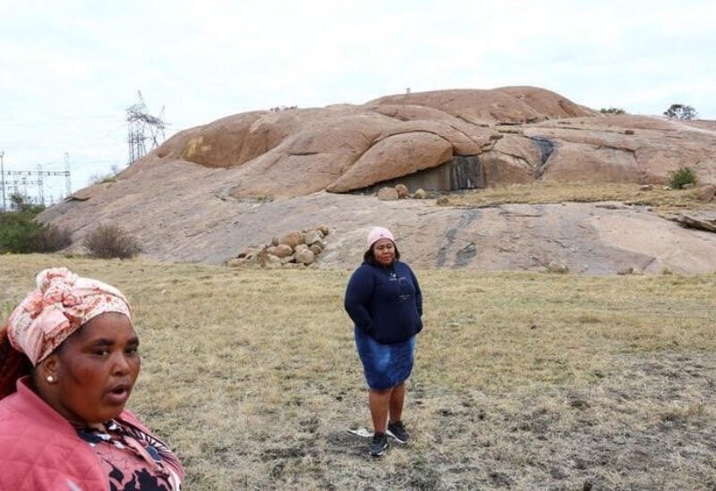 Zameka Nungu and Nosihle Ngweyi, two widows who lost their husbands during the brutal killing of miners, speak about how life has not changed for the better, in front of the hill where police killed 34 miners in 2012 in the "Marikana massacre", near the Lonmin mine in Rustenburg, northwest of Johannesburg July 19, 2022. REUTERS/Siphiwe Sibeko