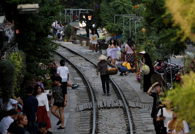 A vendor walks on a railway track as tourists gather on either side, in the Old Quarter of Hanoi, Vietnam September 28, 2019. REUTERS/Kham