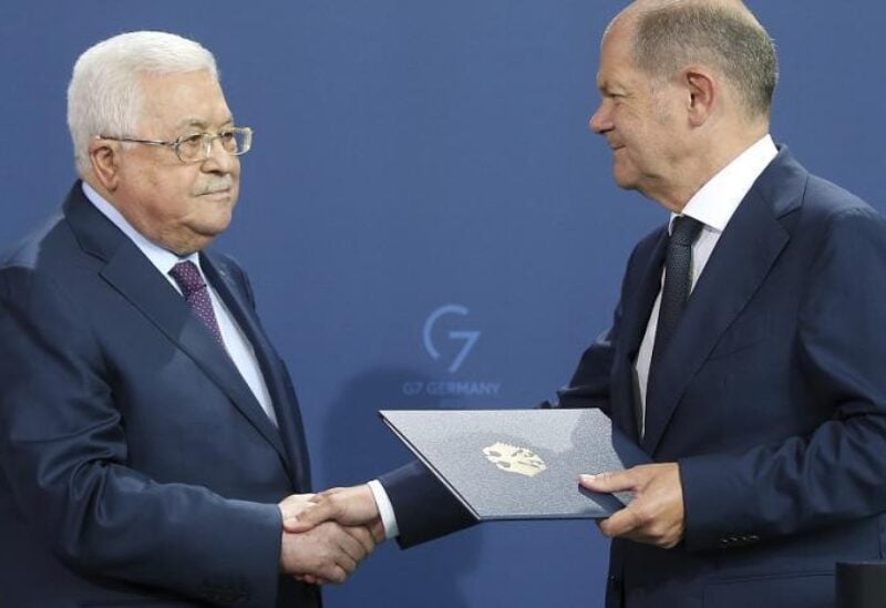 German Chancellor Olaf Scholz, right, and Mahmoud Abbas, President of the Palestinian Authority, shake hands after a press conference following talks in Berlin, Germany, Tuesday, Aug.16, 2022. (AP)